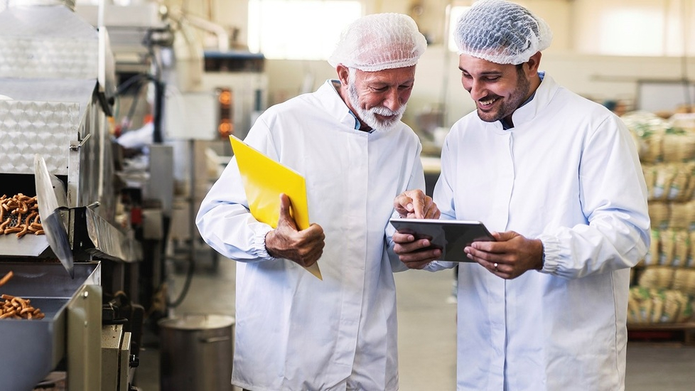 食品制造厂里工人们正在使用平板电脑 