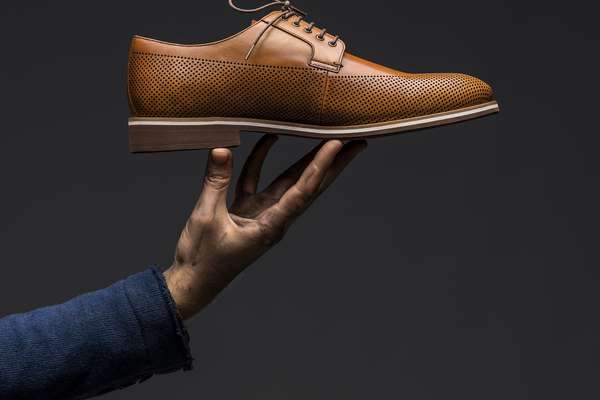 男子举着一只皮鞋