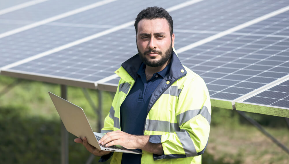 工人站在太阳能电池板前使用 Infor MES