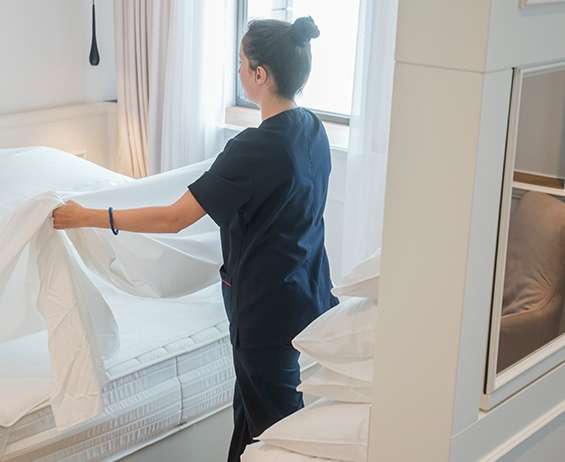 酒店房务服务工作人员在客房里整理床铺