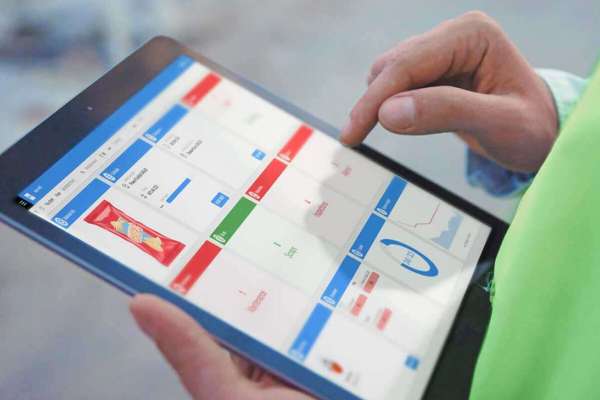 工厂工人在平板电脑上使用 Infor MES 软件控制操作