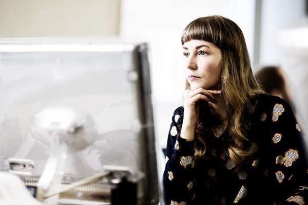 办公室内，女性员工使用电脑操作 Infor iPaaS 解决方案并思考