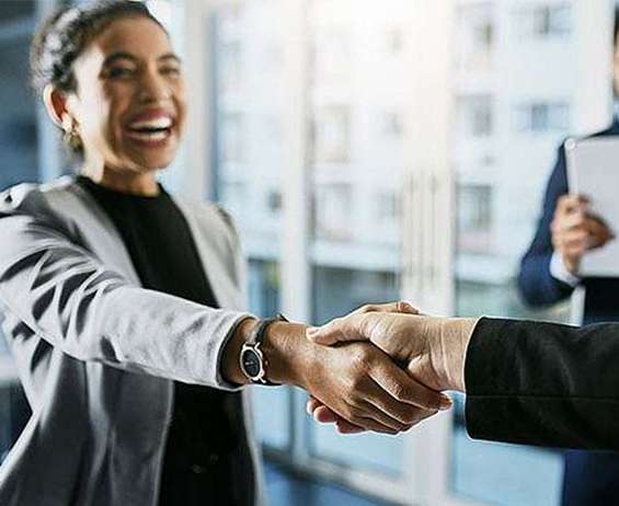 面带微笑的女士与潜在业务客户握手。